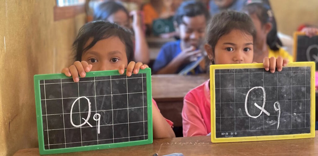 Students in Cambodia showing their chalkboards