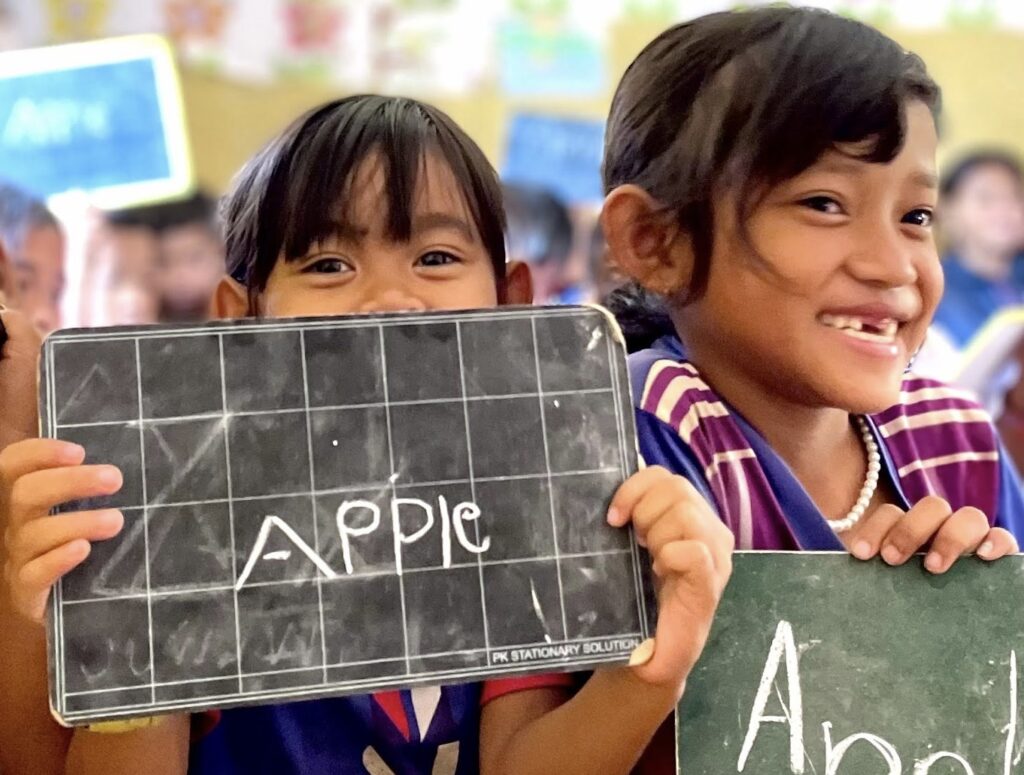 Students in Cambodia showing their chalkboards